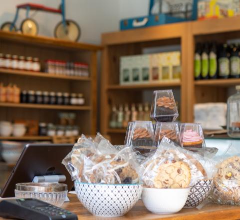 A variety of baked goods on a counter in front of store shelves